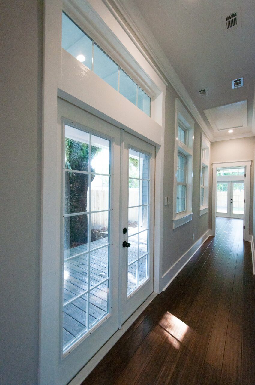 Long hallway with french doors, windows and transom windows in Shotgun Cottage on Lloyd Street in East Hill